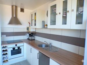 a kitchen with white cabinets and a sink at Studio entre Mer et Lagune in Saint-Aygulf +7 photos