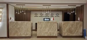 a lobby with clocks on the wall and tables at The Green Park Bostancı in Istanbul