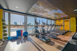 a gym with several treadmills and a swimming pool at The Green Park Bostancı in Istanbul