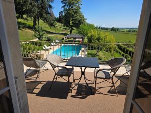 a patio with a table and chairs and a pool at Domaine des Chailloux in Jully-lès-Buxy