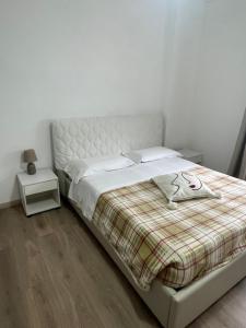 a bedroom with a bed with a plaid blanket at Casa Alessia Sanremo in Sanremo