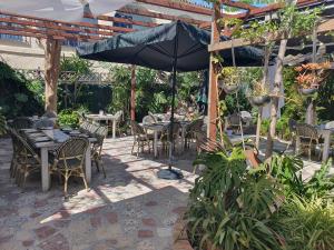 a patio with tables and chairs and an umbrella at Hostal Mi Campaña in Denia +27 photos