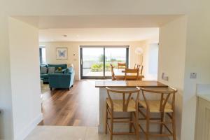 a kitchen and living room with a table and chairs at The Summit - Skellig Coast in Cahersiveen