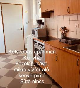 a kitchen with a sink and a stove top oven at Téesz Vendégház in Zalaháshágy +12 photos