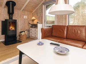 a living room with a couch and a fireplace at 4 star holiday home in Jerup in Jerup