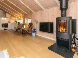 a living room with a fireplace and a tv at 4 star holiday home in Jerup in Jerup +25 photos