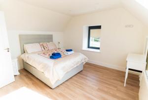 a white bedroom with a bed and a desk at The Summit - Skellig Coast in Cahersiveen