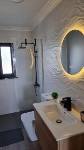 a bathroom with a sink and a toilet and a mirror at Mar & Monte in Angra do Heroísmo +34 photos