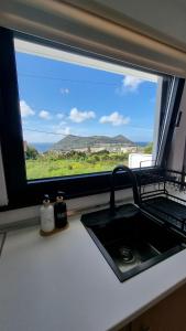 a kitchen counter with a sink and a window at Mar & Monte in Angra do Heroísmo
