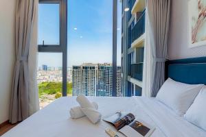 a bedroom with a bed with a view of a city at Eco Green Apartment Residence District 7 in Ho Chi Minh City +117 photos
