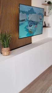 a flat screen tv sitting on top of a white table at Mar & Monte in Angra do Heroísmo