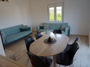 a living room with a table and chairs and a couch at Adria in Pašman +4 photos