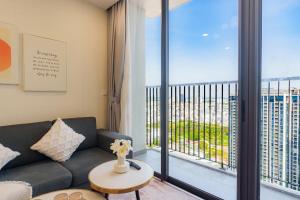 a living room with a couch and a large window at Eco Green Apartment Residence District 7 in Ho Chi Minh City