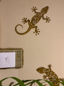 two lizard wall decals on a bathroom wall at Lotus Lodge Ocean View in Port Mathurin