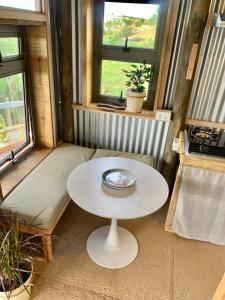 a small white table in a room with windows at Lotus Lodge Ocean View in Port Mathurin