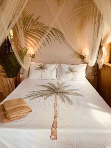 a bedroom with a bed with a palm tree on it at Lotus Lodge Ocean View in Port Mathurin