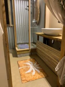 a bathroom with a shower and a rug on the floor at Lotus Lodge Ocean View in Port Mathurin +55 photos