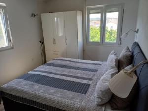 a bedroom with a bed and two windows at Adria in Pašman