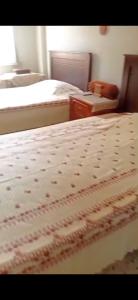 a bedroom with two beds and a dresser and a bed sidx sidx at Penthouse Sea Apartment in El Mîna