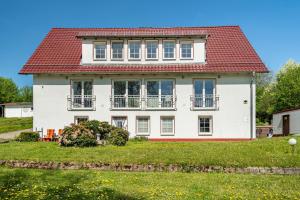 a white house with a red roof at Ferienapartment Sunshine in Zwinge