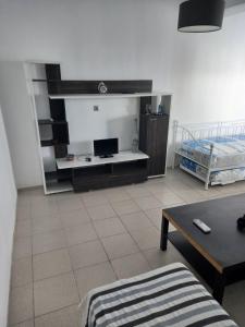 a living room with a tv and a couch and a table at Apartment PAPAS in Mastihari