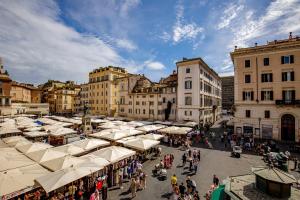 a crowd of people walking around a market with umbrellas at Al centro di Roma in Rome