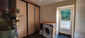 a laundry room with a washing machine and a window at Gite le rémijour in Céaux-en-Couhé