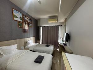 a hotel room with two beds and a television at Collection O Expressia Stay in Tangerang