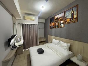 a hotel room with a bed and a television at Collection O Expressia Stay in Tangerang
