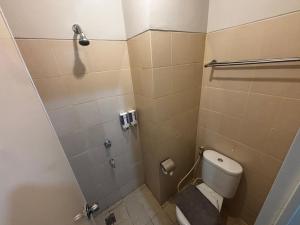 a small bathroom with a toilet and a shower at Collection O Expressia Stay in Tangerang +20 photos