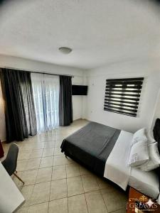 a bedroom with a large bed in a room with windows at Griavas at campsite in Sykia Chalkidikis