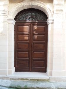 una grande porta in legno in un edificio in pietra di Casa Majore a Chiaramonte Gulfi