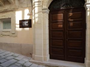 una grande porta di legno sul lato di un edificio di Casa Majore a Chiaramonte Gulfi