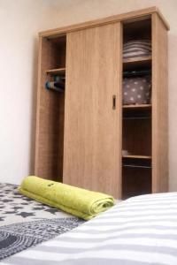 a bed with a wooden cabinet with dishes in it at Budget Friendly -Private Room in a Moroccan Home - Host On Site in Agadir