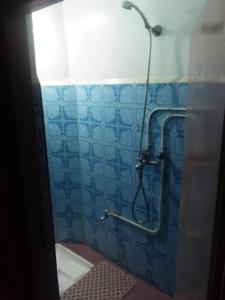 a shower in a bathroom with a blue tiled wall at Budget Friendly -Private Room in a Moroccan Home - Host On Site in Agadir