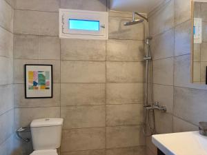 a bathroom with a toilet and a sink and a window at Themis in Aghia Marina +10 photos