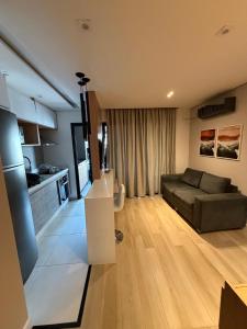 a living room with a couch and a television at Piscine Statio Resort Brás in São Paulo