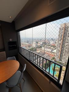 a large window in a room with a table and chairs at Piscine Statio Resort Brás in São Paulo
