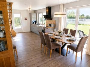 a dining room and kitchen with a table and chairs at Reetdachhaus 1, inkl 2 Parkplätze in Fehmarn