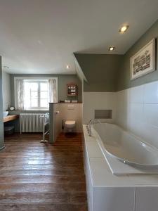 a large bathroom with a tub and a toilet at Bed & Breakfast Esprit de Mer in De Panne +28 photos