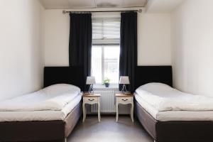 two beds in a room with a window at Trossö Vandrarhem in Karlskrona