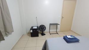 a white room with a bed and a fan at Estadia Do Vale Hospedaria União da Vitória in União da Vitória
