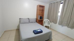 a small bedroom with a bed and a chair at Estadia Do Vale Hospedaria União da Vitória in União da Vitória