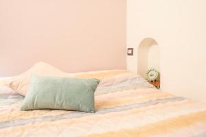 a bed with a green pillow on top of it at Manzi 40 in Civitavecchia