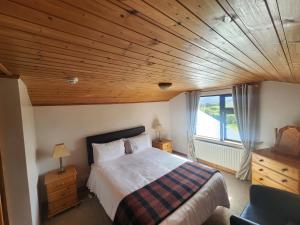a bedroom with a large bed with a wooden ceiling at Ben Breen House Apartment in Crockaunroe