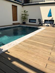 a swimming pool with a wooden deck in a building at L'échappée de Bras Long in Entre-Deux