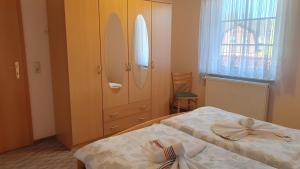 a bedroom with two beds and a cabinet and a window at Ferienwohnung 2 in Bad Wilsnack
