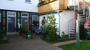 a house with a patio and a stairway with flowers at Ferienwohnung 2 in Bad Wilsnack