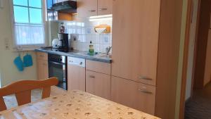 a kitchen with wooden cabinets and a table with a tableablish at Ferienwohnung 2 in Bad Wilsnack +4 photos