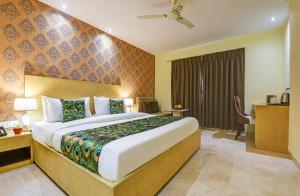 a hotel room with a bed and a desk at Hotel Mayur in New Delhi